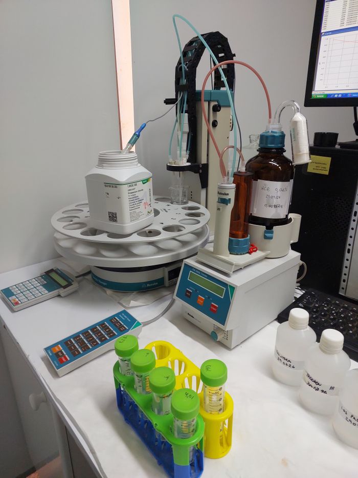 Menu Scientific laboratory equipment with titration apparatus and chemical containers.
